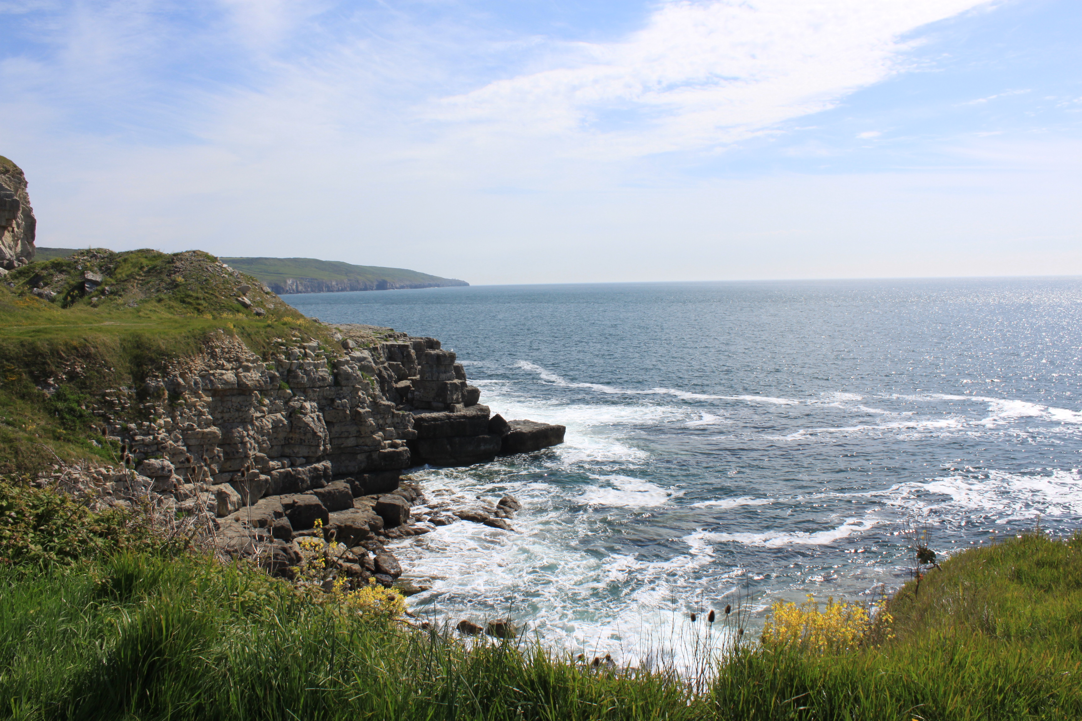 an image of a rocky cliff with waves crashing against it.