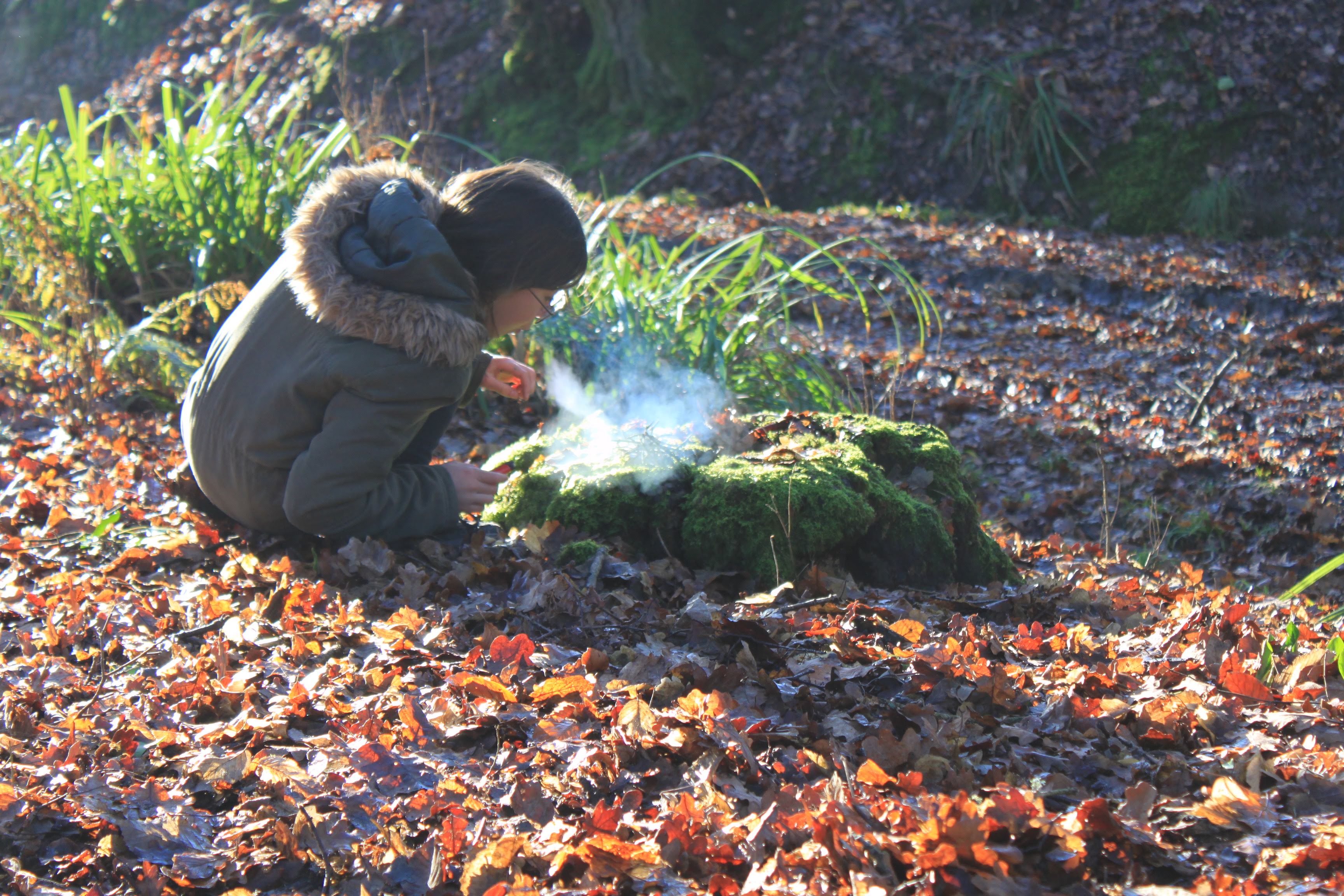 an image of a young girl who is blowing smoke into a tree trunk.