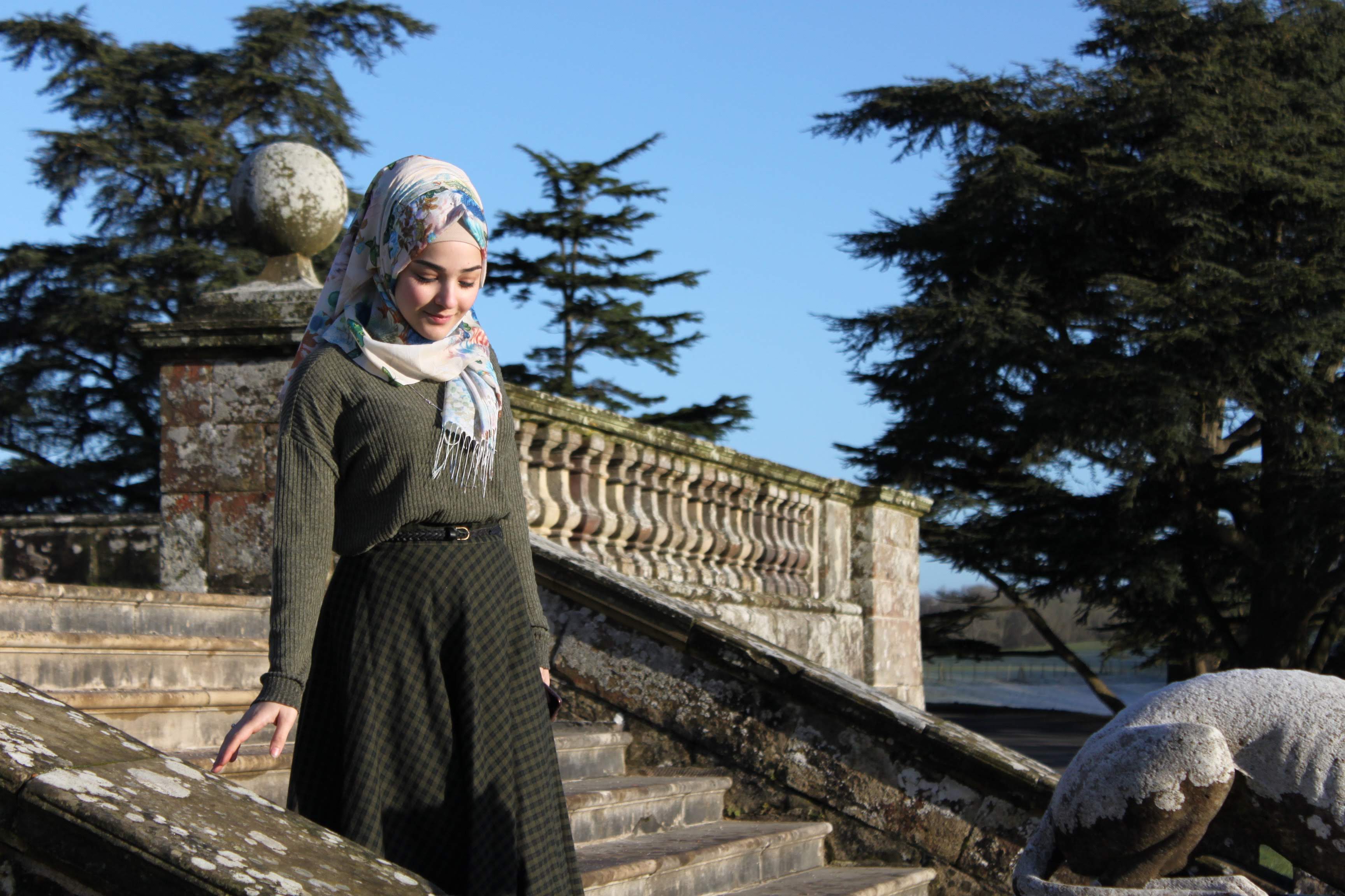 an image of a muslim teenager wearing a hijab who is walking down some stairs.